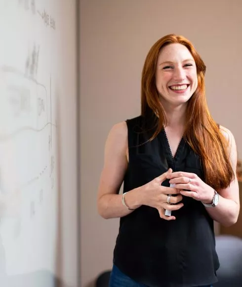 Rothaarige Frau mit schwarzem Oberteil lacht