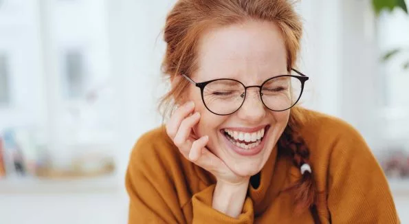 lachende Dame in orangenem Pullover