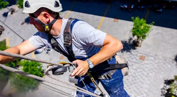 Mann reinigt Außenfassade