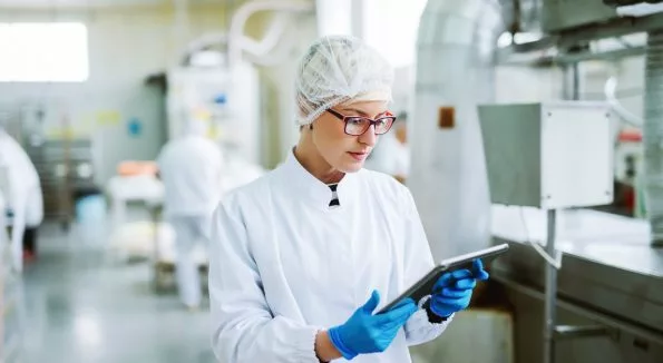 Frau steht mit Tablet in Labor