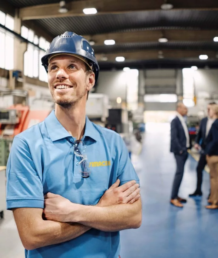 Mann mit blauem Simacek-T-Shirt steht in Lagerhalle